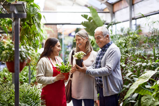 istock Confident owner with customers at garden center 1207038346