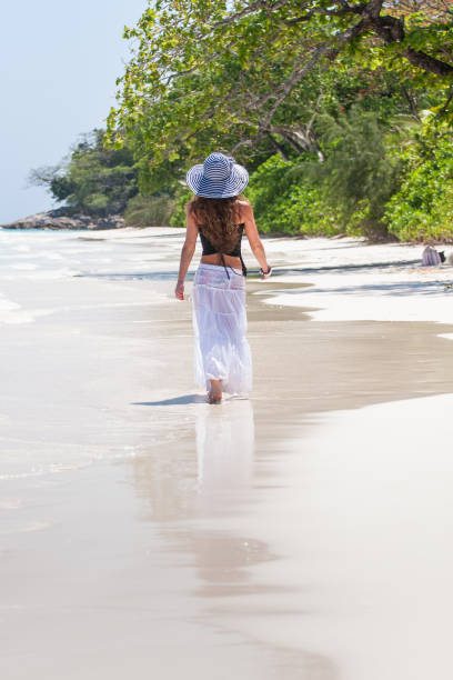 istock Young woman walks along the beach 1207039738