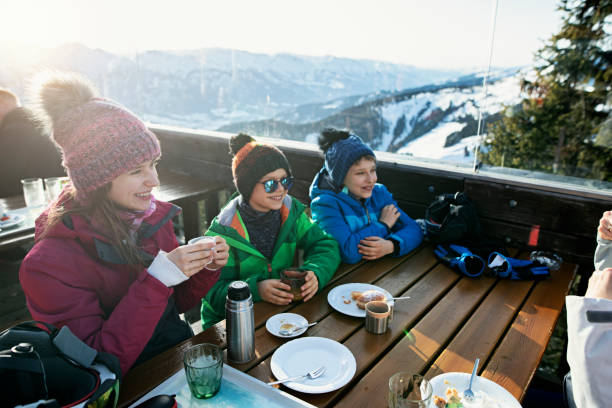 kleine skifahrer essen mittagessen in alpiner skibar - apres ski friendship skiing enjoyment stock-fotos und bilder
