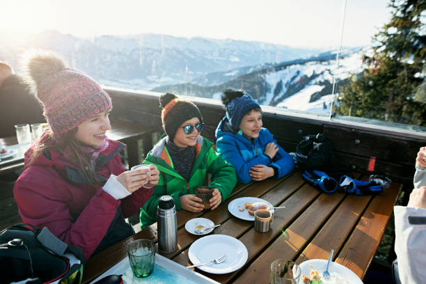 little skiers eating lunch in alpine ski bar - apres ski snow winter european alps imagens e fotografias de stock