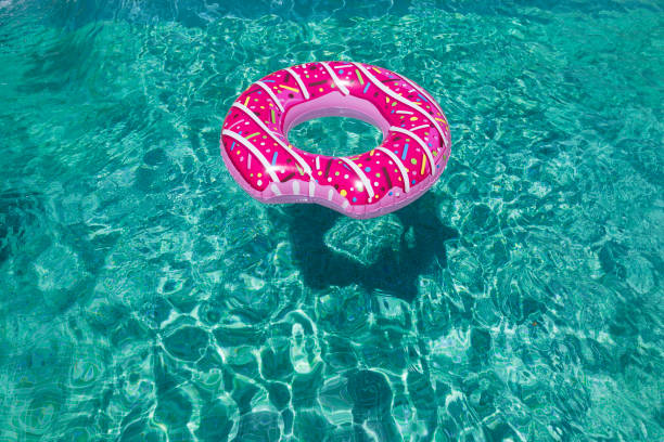 istock modern sprinkled donuts inflatable float in sunny pool background straight down on bright clear pool water. Summer concept, relax and lifestyle 1207041290