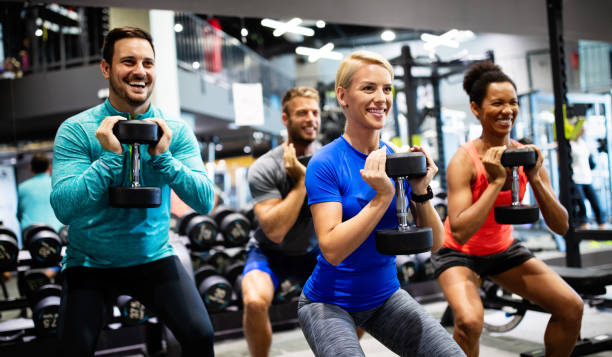 Group of young happy fit people doing exercises in gym Group of young people fit friends doing exercises in gym athleticism stock pictures, royalty-free photos & images