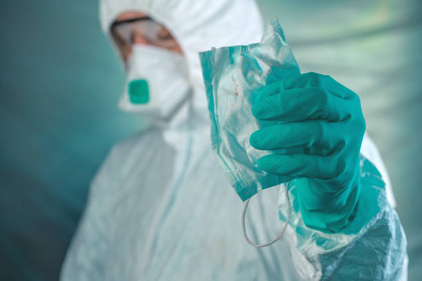 istock Epidemiologist holding respiratory mask with blood stains 1207042069
