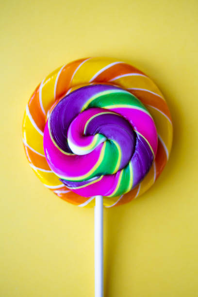 istock Bright swirl lollipops on yellow background 1207044871