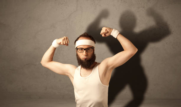 istock Skinny man with musculous shadow 1207044958