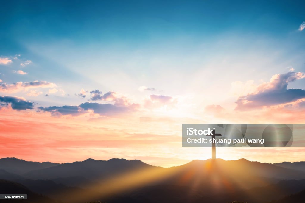 Silhouette cross on mountain sunset background Religious Cross Stock Photo