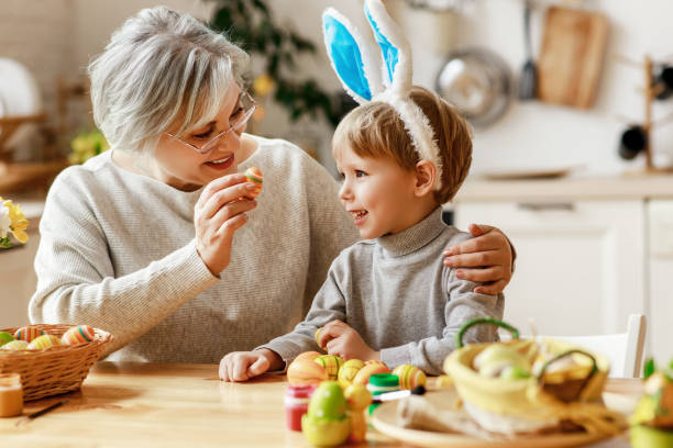 ハッピーイースター!家族の祖母と耳のhareは休日の準備をしています - grandmother child senior adult multi generation family ストックフォトと画像