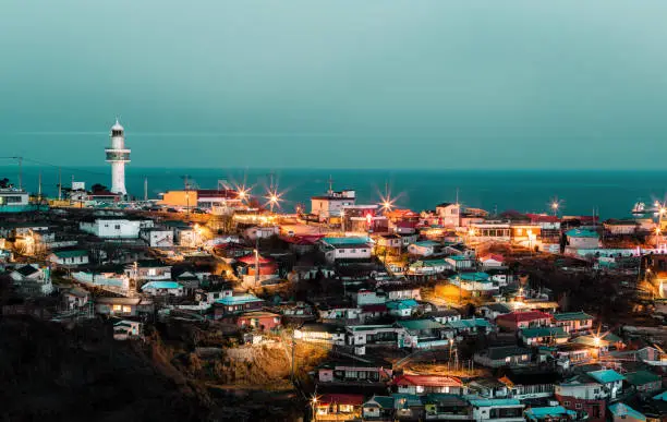 light house on dark night at harbor villiage in southkorea.