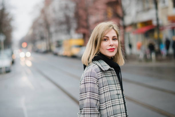 woman crossing a street in the city young woman running across the street of a big city friedrichshain photos stock pictures, royalty-free photos & images