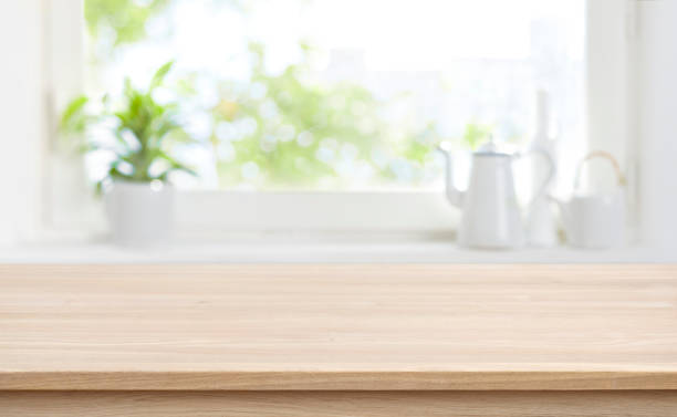 istock Wooden kitchen table with background of window for product display 1207049518