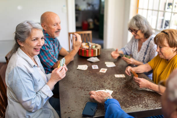 istock Seniors playing cards in their retirement home 1207050431