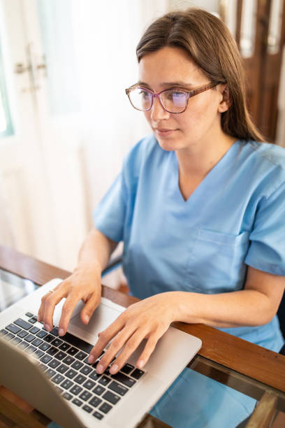 медсестра-женщина, работающая с помощью ноутбука в доме престарелых - laptop doctor using computer nurse стоковые фото и изображения