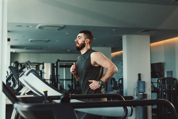 istock Young man running on treadmill at gym 1207050640
