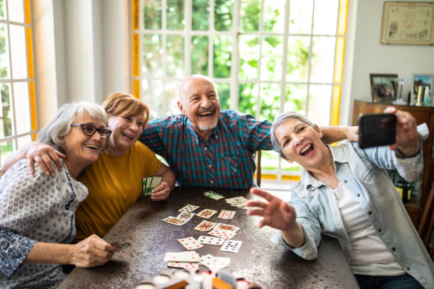 istock Happy senior friends taking selfie while playing cards at home 1207051257