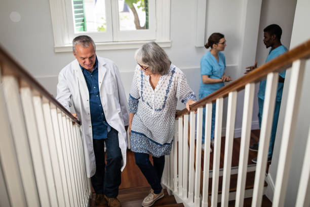 의사와 노인 여성이 계단에서 올라가 서 은퇴 가정에서 이야기 - senior adult close to moving up togetherness 뉴스 사진 이미지
