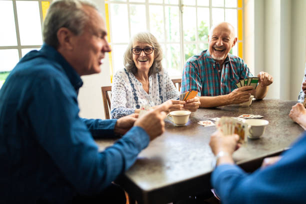 istock Senior friends playing cards at home 1207051954