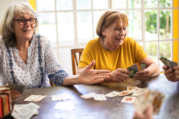 istock Happy seniors playing cards at nursing home 1207052193