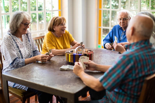 istock Happy friends having fun time playing cards at home 1207052317