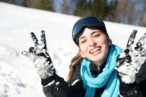 Young cheerful girl having fun in the snow