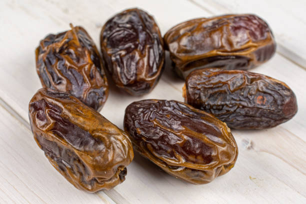 istock Dry brown date fruit on grey wood 1207054168