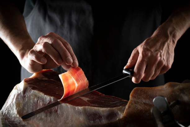 иберийская ветчина серрано ветчина ломтик резки руки и нож - ham kitchen knife meat iberian стоковые фото и изображения