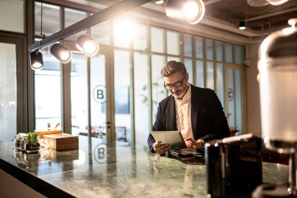 istock Mature businessman using digital tablet at modern office 1207056123