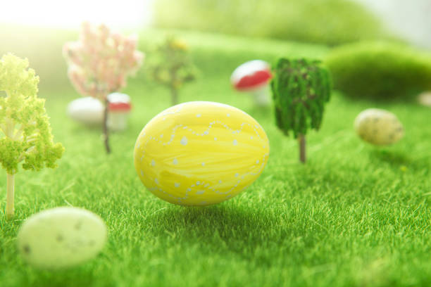 istock Yellow Easter egg outside in grass with evening sun from behind 1207056428