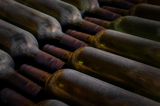 Old red wines are stored in green bottles in the wine cellar