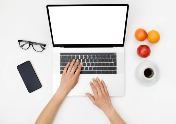 istock Top view of beautiful woman 's hands using laptop placed on white desktop. Flat lay 1207056887