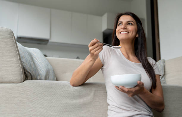 istock Happy woman eating breakfast at home 1207059272