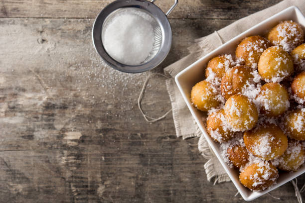 Carnival fritters or buñuelos de viento for holy week Carnival fritters or buñuelos de viento for holy week on wooden table fritter photos stock pictures, royalty-free photos & images