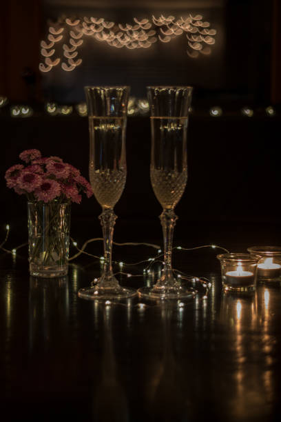 istock Champagne and pink flowers on dark table for romantic dinner date night 1207061151