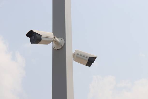 istock two closed-circuit television on white pole against sky background 1207061308