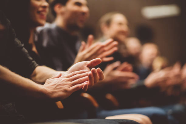 Audience applauding in the theater Group of people clapping hands in the theater, close up of hands. Dark tone. applauding photos stock pictures, royalty-free photos & images