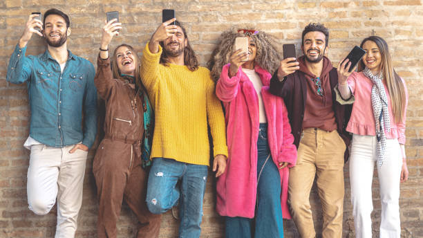 istock Group of multicultural friends using smartphone outdoors against a break wall - People addicted by mobile smart phone - Technology and social media concept with connected men and women 1207063256