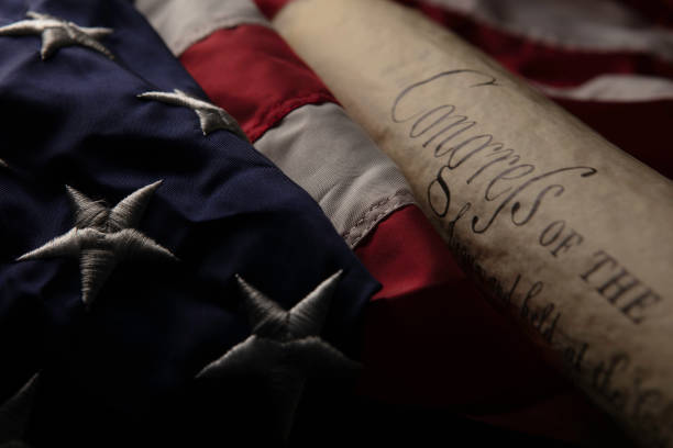 American flag with rolled-up of constitution document on wooden table