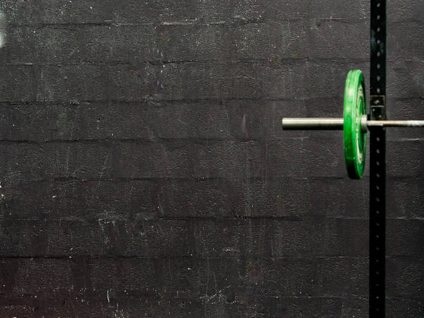 Green barbells on black background with copy space