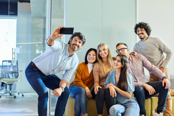 istock Male and female colleagues taking selfie in office 1207068024
