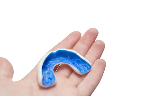 White custom sport mouthguard on a hand. White custom sport mouthguard on a hand. Individual professional sport equipment. mouthguard stock pictures, royalty-free photos & images