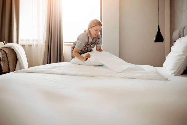 Maid working making the bed at a hotel Maid working at a hotel making the bed housekeeping staff photos stock pictures, royalty-free photos & images