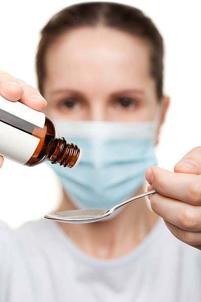 istock Doctor in mask holding medicine syrup 120707235
