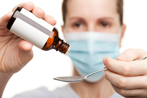 istock Doctor in mask holding medicine syrup 120707259