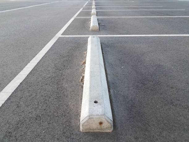 istock cement curb in parking lot with asphalt 1207074055