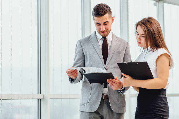 istock Successful man and woman making business plan, comparing each other researches. 1207075411