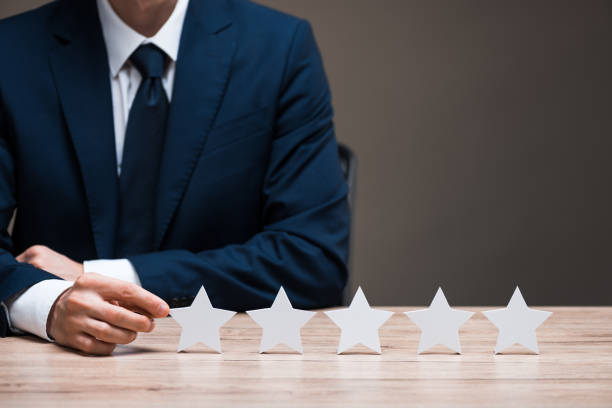 istock selective focus of man in suit touching star isolated on grey, quality concept 1207075785