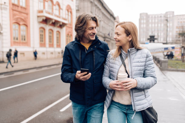 istock Happy mature couple walking and using smartphone 1207075915