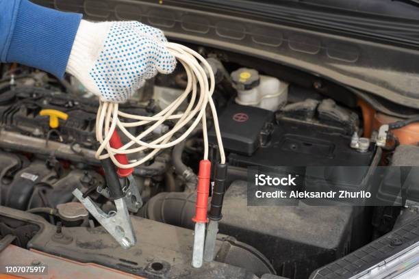 Jumpstart For A Car In The Mechanics Hand The Jumper Cable Stock Photo - Download Image Now