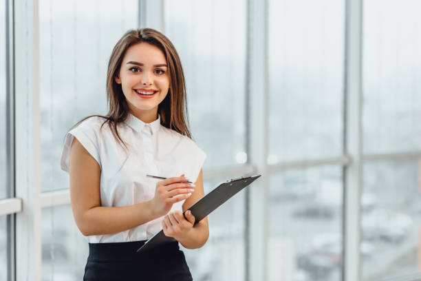 pesquisador em trajes de negócios formais escreve informações sobre prancheta, isolada em branco. - inspector clipboard businesswoman white collar worker - fotografias e filmes do acervo