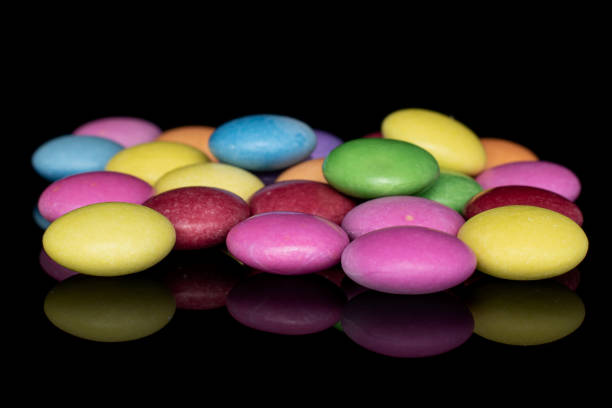 istock Sweet colourful candy isolated on black glass 1207079442