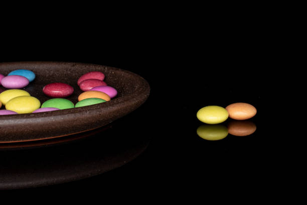istock Sweet colourful candy isolated on black glass 1207079452